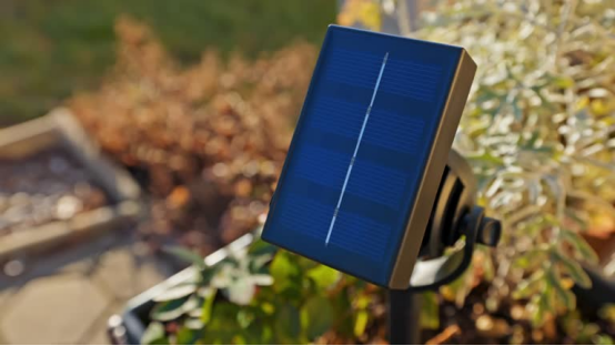 A solar panel powers an outdoor wall light, showcasing renewable energy use.